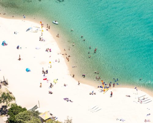 aerial-of-people-on-the-beach-and-in-ocean-(1)