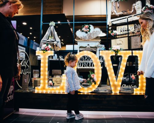 robina-town-centre-the-kitchens-mother-with-daughter-outside-love-sign-in-window-of-newsagent